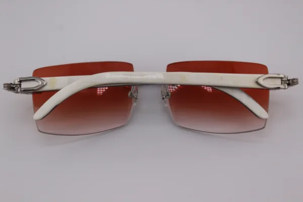 Custom handcrafted iced out buffalo horn sunglasses featuring premium white genuine horn temples, VVS1 moissanite corner accents, and an iced out nose bridge with 58mm red tint gradient lenses - one-of-a-kind luxury eyewear made in Michigan